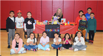 13 students beside a table decorated with Kiddsmiles items thumbnail265589